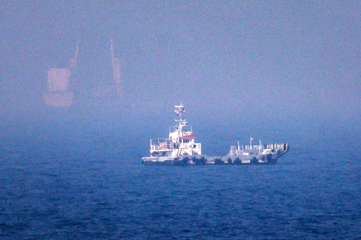 This picture shows ships sailing near the Strait of Hormuz off the eastern coast of the United Arab Emirates at Khor Fakkan on July 13, 2026. The United States is "taking over" the Strait of Hormuz and will be paid for protecting it, President Trump declared on July 13, as Washington and Tehran once again fought over the vital waterway.