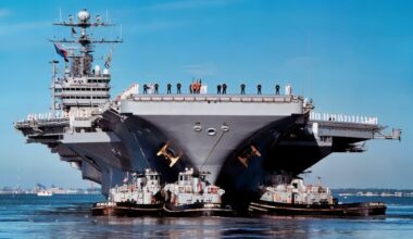 Sailors and Marines man the rail as three harbor tugs push the aircraft carrier USS George Washington (CVN 73) away from Pier 11 at Norfolk Naval Base on Oct. 3, 1997, for a scheduled six-month deployment. The George Washington will relieve the USS John F. Kennedy (CV 67) to conduct operations in the Mediterranean Sea.