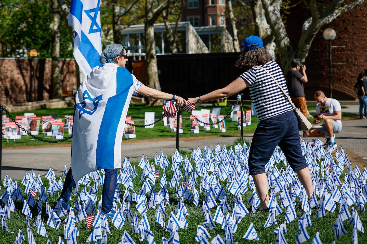 Attendees of the MIT Israel Day celebration placed American flags among Israeli flags nearby a pro-Palestinian encampment on Kresge lawn in May.