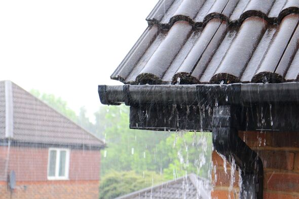 A close-up of a house's gutters during a rain A close-up of a house's gutters during a rain