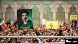 A man holds a placard with an image of Iran's Supreme Leader Mojtaba Khamenei in Tehran on June 4.