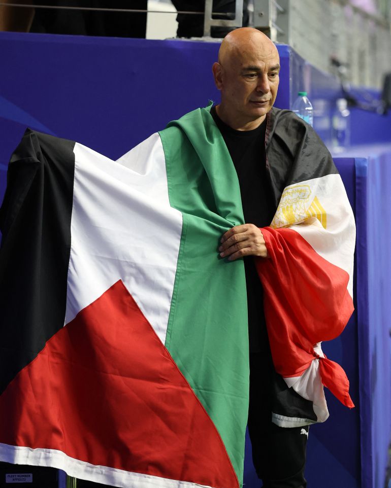 ARLINGTON, TEXAS - JULY 03: Hossam Hassan, Head Coach of Egypt, holds the flag of Palestine after the team's victory through the penalty shootout during the FIFA World Cup 2026 Round of 32 match between Australia and Egypt at Dallas Stadium on July 03, 2026 in Arlington, Texas. Molly Darlington/Getty Images/AFP (Photo by Molly Darlington / GETTY IMAGES NORTH AMERICA / Getty Images via AFP)