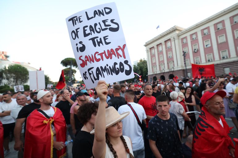 Protesters carry placards as they demonstrate in front of the Albanian Prime Minister's Office against the construction of a luxury resort near a protected natural area on Albania's southern coast, in Tirana, on July 4, 2026.