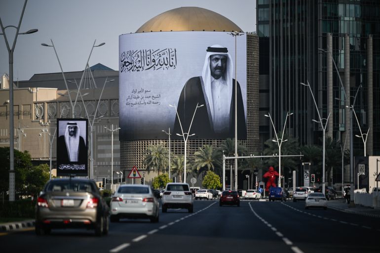 Commuters drive past a billboard bearing a portrait of Qatar's former leader Sheikh Hamad bin Khalifa Al Thani in Doha on July 12, 2026, after the announcement of his death.