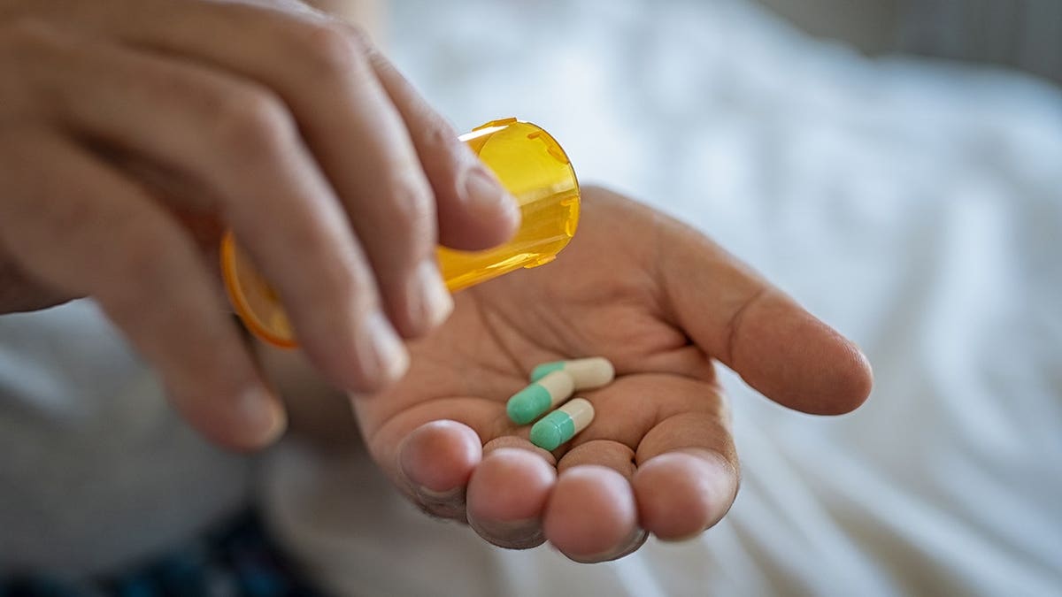 Close up of male hands taking daily dose of drug.