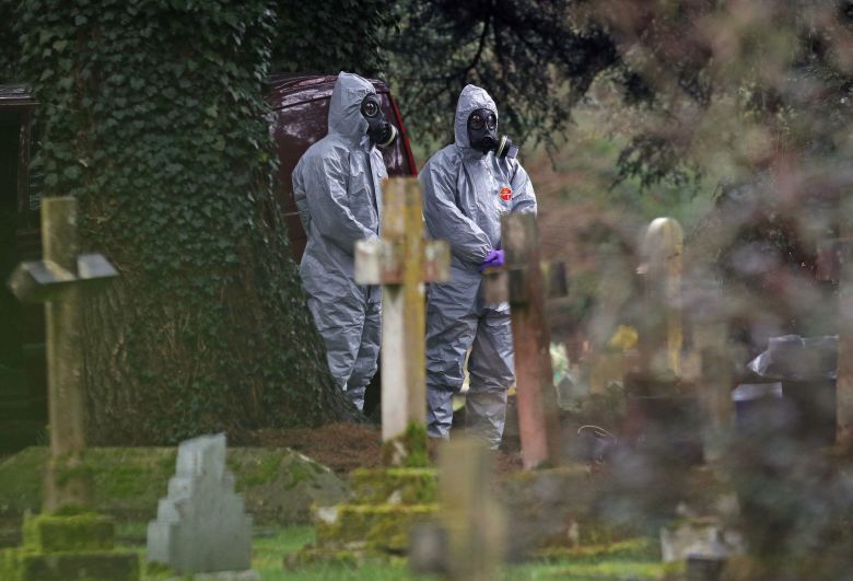 Forensic officers in gas masks examine the London Road cemetery in Salisbury, England, in March 2018. The cemetery houses the remains of former Russian double agent Sergei Skripal's wife and son.