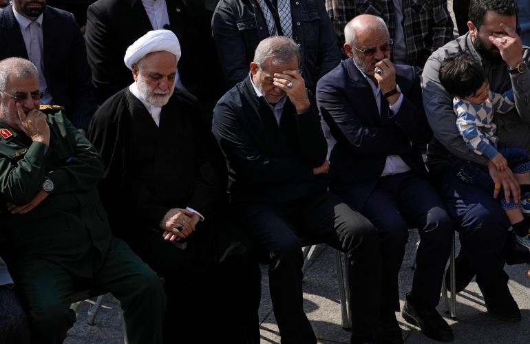 Iranian President Masoud Pezeshkian, center, Judiciary Chief Gholamhossein Mohseni Ejehi, second left, attend the funeral ceremony of the late Revolutionary Guard Gen. Abbas Nilforushan, in Tehran, Iran, Tuesday, Oct. 15, 2024. (AP Photo/Vahid Salemi)