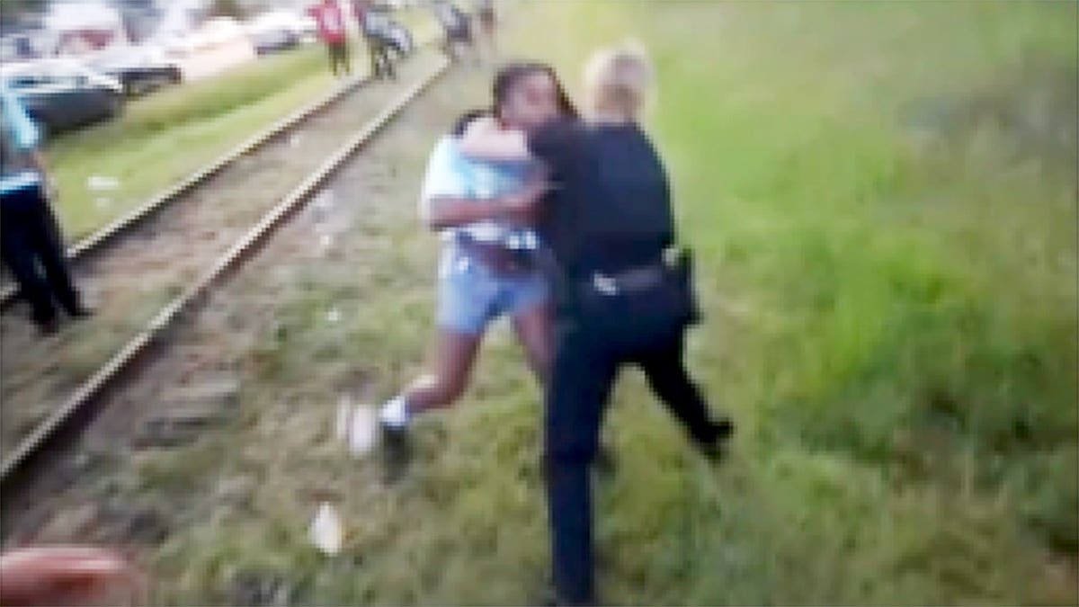 A North Charleston police officer struggles with a woman during an arrest at a Fourth of July block party