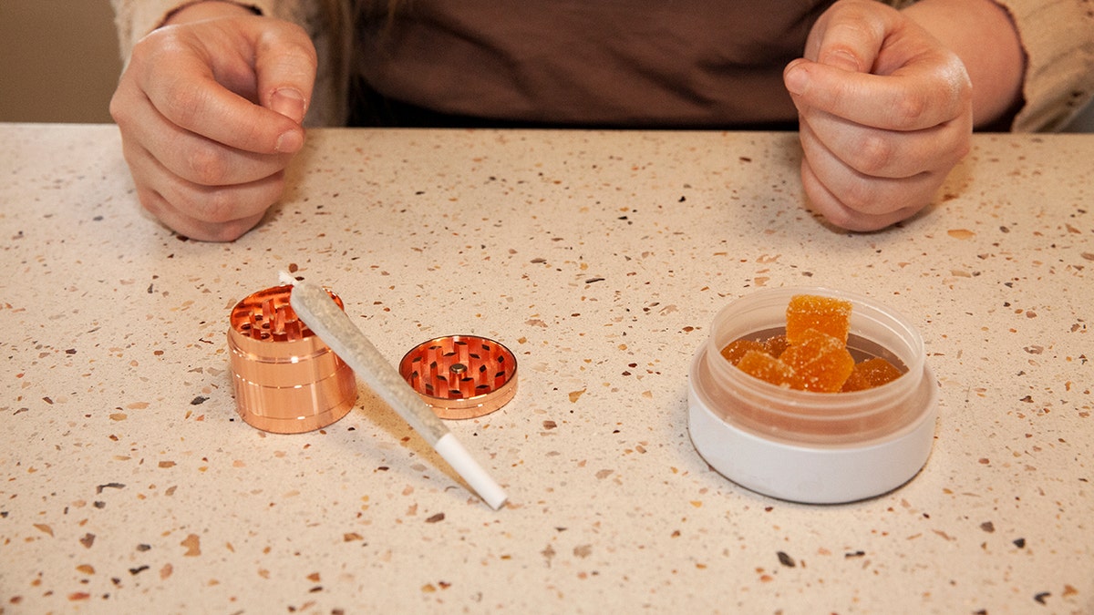 Saleswoman shows Cannabis gummies and pre-roll at dispensary