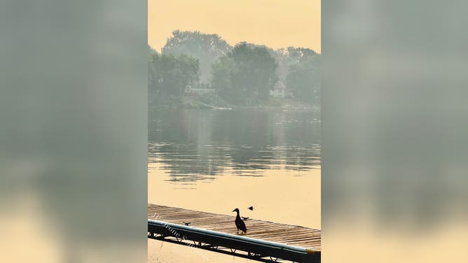 Orange skies reflect over a lake in Champlin, MN, on July 16.