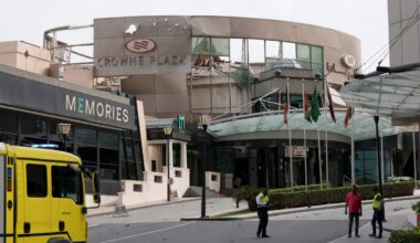 Security and civil defense workers stand outside the damaged Crown Plaza hotel, following an Iranian military strike, in Manama on March 1, 2026.