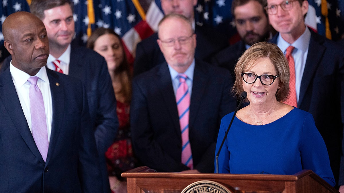 Newly-appointed U.S. interim Senator Darline Graham Nordone, right, with Sen. Tim Scott, R-S.C., left, speaks during a press conference announcing her appointment to fill the vacancy created by the passing of her brother, U.S. Sen. Lindsey Graham, at the statehouse Monday, July 13, 2026, in Columbia, S.C. (AP Photo/Sean Rayford)