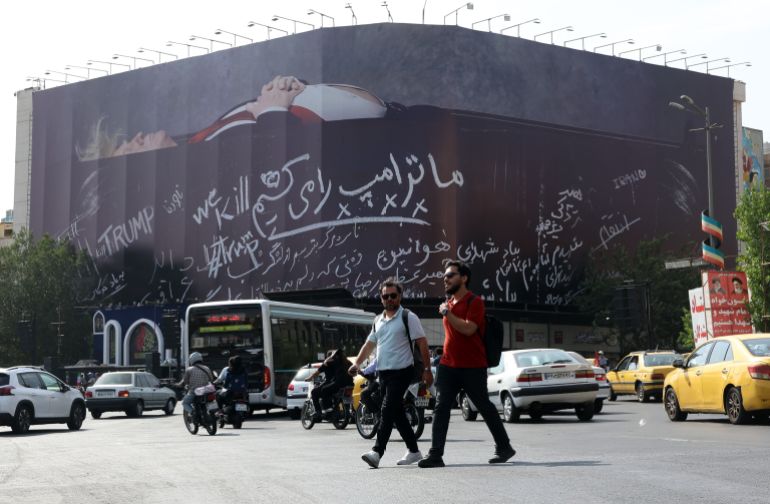 epa13126439 Iranians walk past an anti-US billboard depicting US President Donald Trump in a coffin alongside the slogan 'We Kill Trump' at Enghelab Square in Tehran, Iran, 22 July 2026. Tensions between Iran and the US continue over the Strait of Hormuz following US strikes on several locations across Iran. EPA/ABEDIN TAHERKENAREH RESTRICTIONS: NO Access Israel Media/Persian Language TV Stations Outside Iran/Strictly No Access BBC Persian/VOA Persian/Manoto TV/Iran International TV. (As mandated by Iran's Directorate General for Foreign Media) --