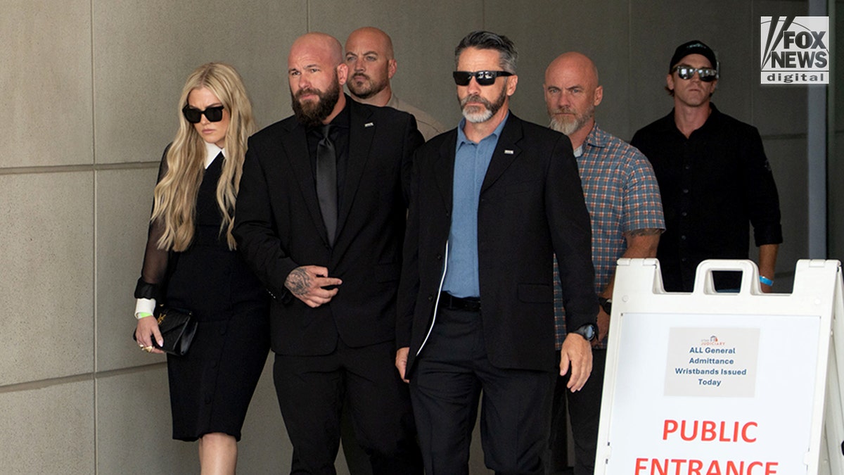 Erika Kirk, left, wearing a black dress and sunglasses as she leaves the Fourth District Courthouse in Provo