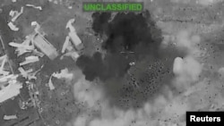 Scattered debris and smoke, at an unknown location, during what the U.S. Central Command (CENTCOM) says are strikes on Iran