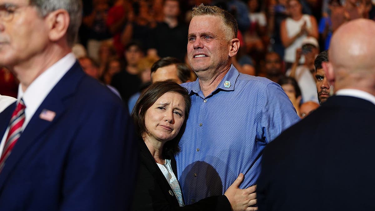 Shari and Stephen Feehan listen as President Donald Trump honors their son at Wheeler High School in Marietta, Georgia