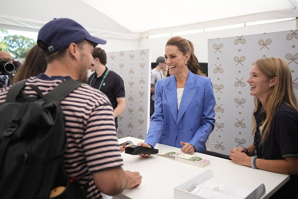 TENNIS-GBR-WIMBLEDON-ROYALS britains catherine, princess of wales (c) helps out in the ticket office as she pays a visit on the fourth day of the 2026 wimbledon championships at the all england lawn tennis and croquet club in wimbledon, southwest london, on july 2, 2026. (photo by andrew matthews / pool / afp via getty images) / restricted to editorial use no commercial use without prior written consent of the aeltc. just still image use no moving images to emulate broadcast. no superimposing or removal of sponsor/ad logos.