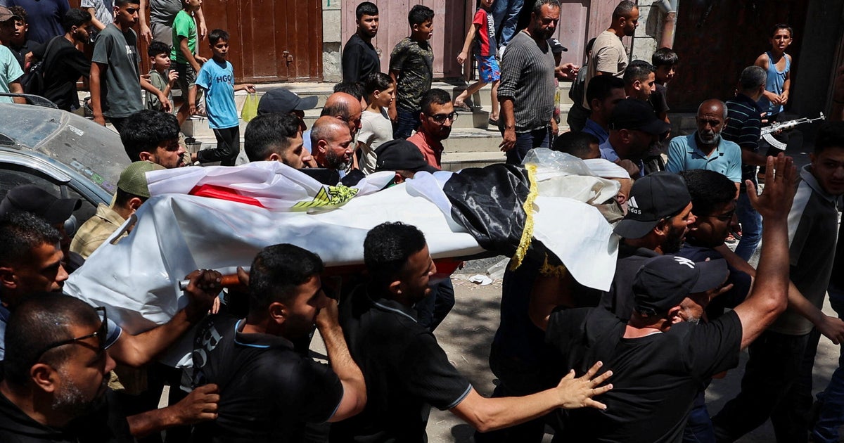 Mourners carry the body of Palestinian man Mohammad al-Waheidi, who worked for the Egyptian Relief Committee and was killed in an Israeli strike on Tuesday, during his funeral, in Gaza