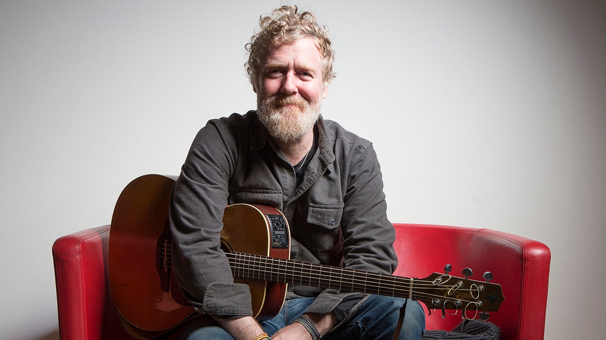 Glen Hansard poses for a photo with guitar