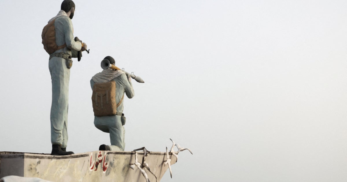 FILE PHOTO: A statue of Iranian military members stands as vessels in the Strait of Hormuz are visible near the beach of Bandar Abbas