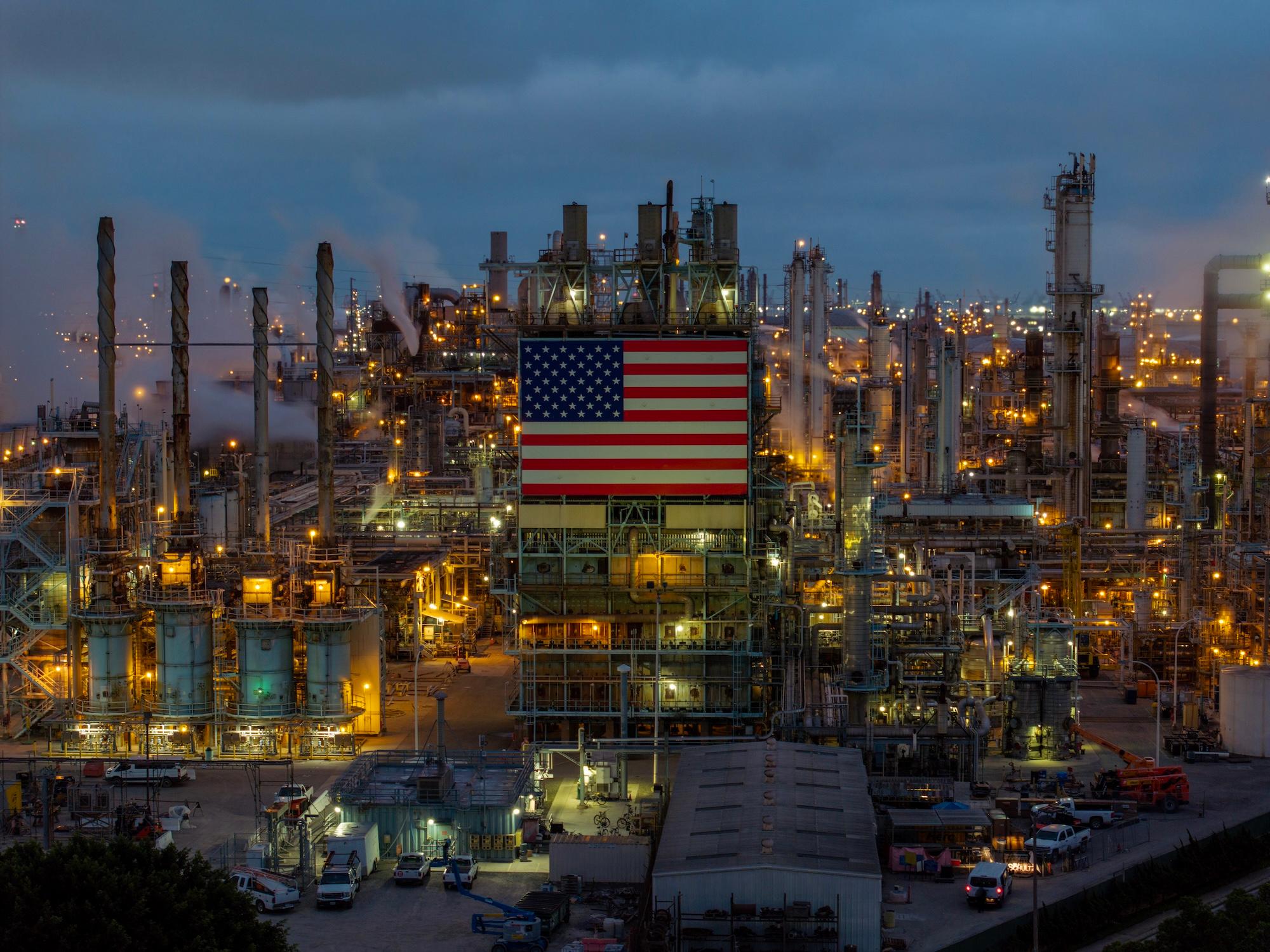 a large american flag flies at a refinery in California