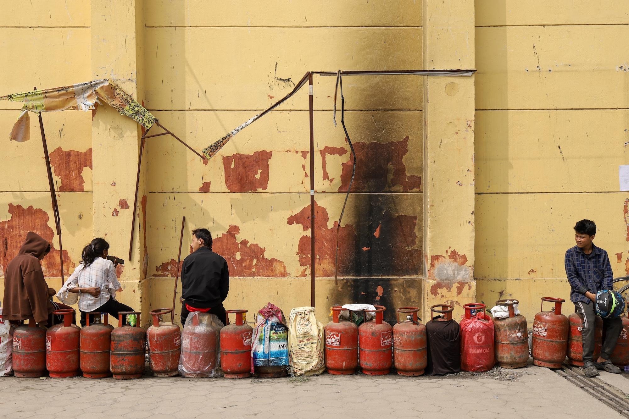 a line of people carrying mobile gas cylinders