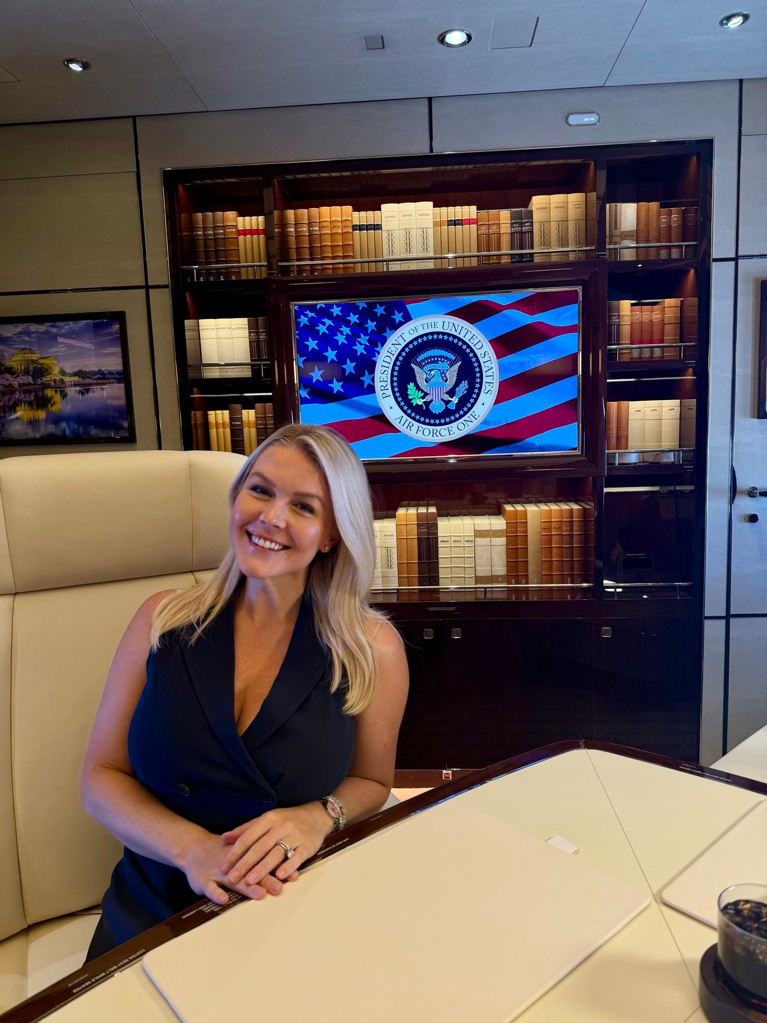 Karoline Leavitt was on board Air Force One’s inaugural flight - and posted a photo in front of what appears to be dozens of fake books