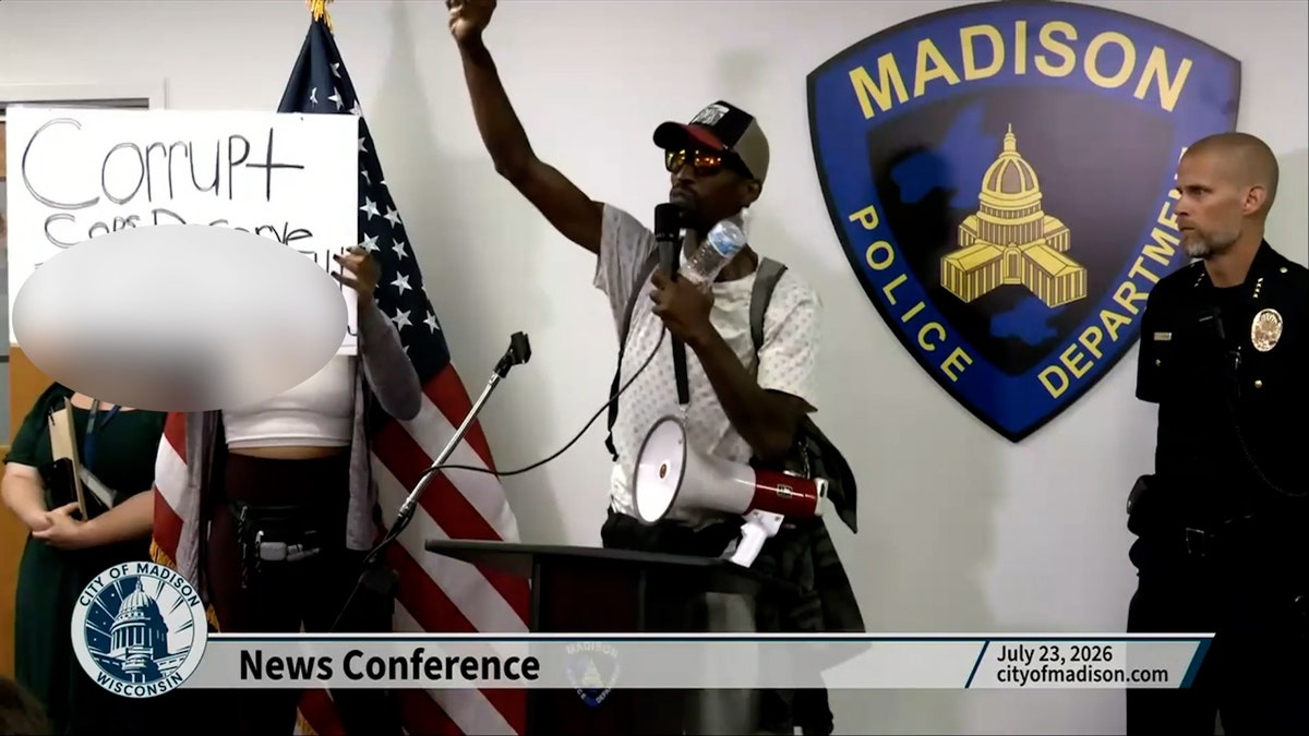 man hurling fist in air at podium
