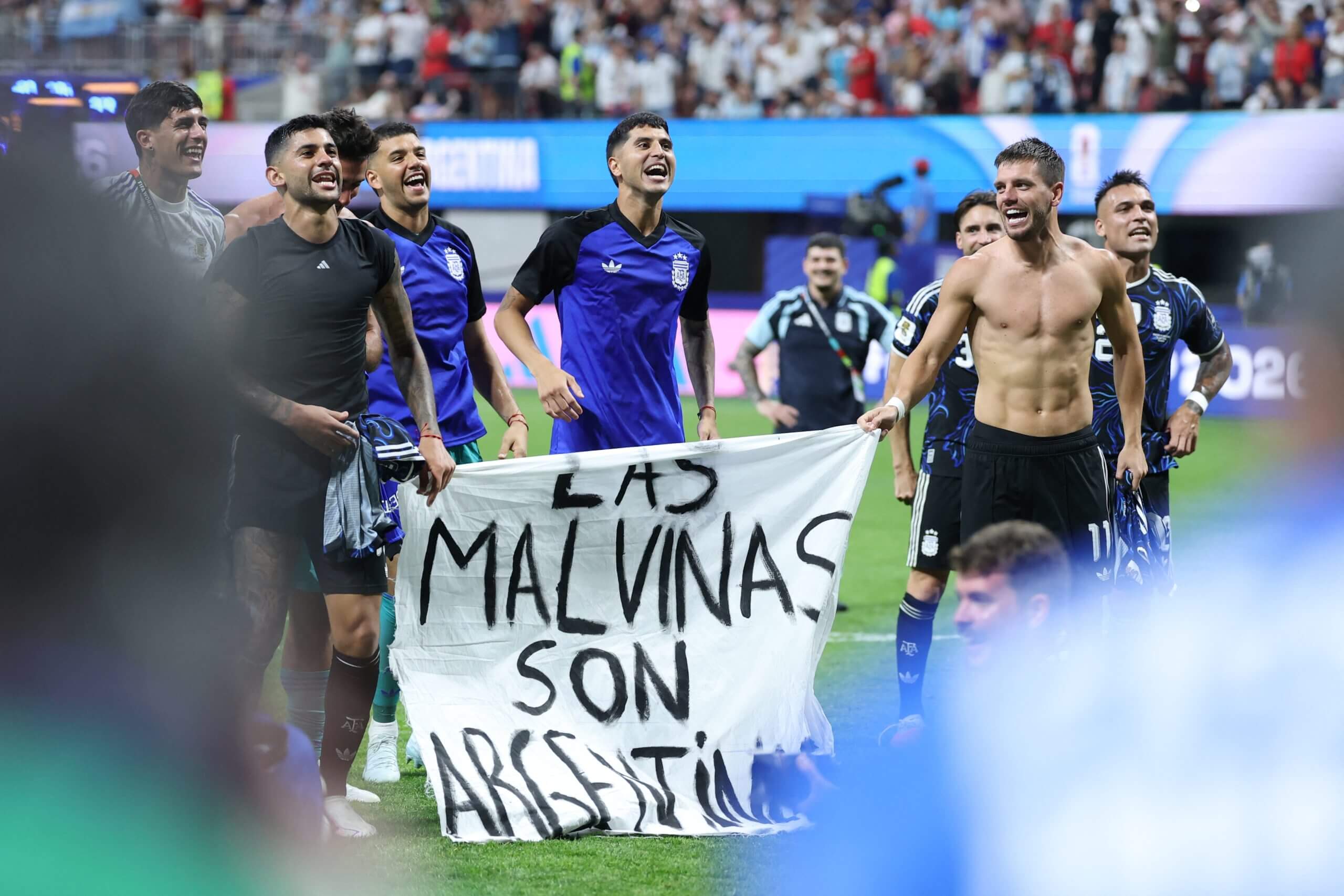Argentina's Cristian Romero and Giovani Lo Celso holding the banner