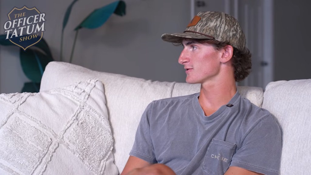 Nolan Wells sitting on a couch, facing right, with "The Officer Tatum Show" logo in the upper left.