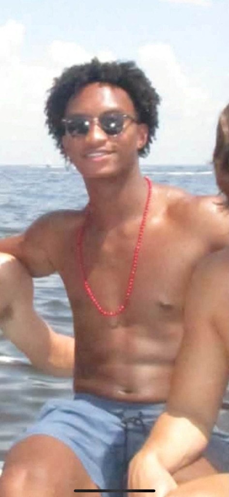 A photo of Nolan Xavier Wells in sunglasses and a red necklace.