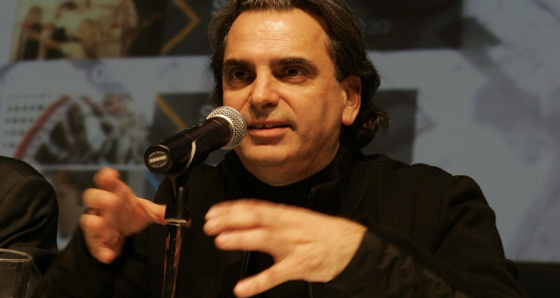 Daniel Langlois speaks into a microphone on a table.