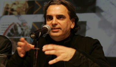 Daniel Langlois speaks into a microphone on a table.