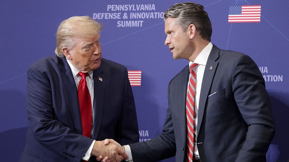 President Donald Trump shakes hands with War Secretary Pete Hegseth