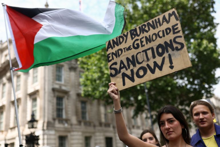 A woman holds a placard outside Downing Street during a "National March for Palestine" calling on Britain's next Prime Minister, Andy Burnham, to stand up for the Palestinian people, in London, Britain, July 18, 2026. REUTERS/Jack Taylor