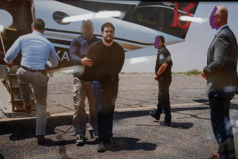 A photo of former Sinaloa Cartel leader Joaquin Guzman Lopez, the son of notorious narco leader "El Chapo" Guzman, being detained by federal agents is displayed next to a Beechcraft King Air aircraft, used in July 2024 to transport to the U.S. Ismael "El Mayo" Zambada and Guzman Lopez, at the War Eagles Air Museum, where the plane is on loan from the FBI, in Santa Teresa, New Mexico, U.S. July 9, 2026. REUTERS/Paul Ratje