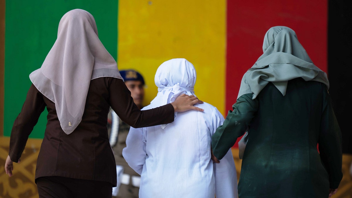 woman escorted by other women