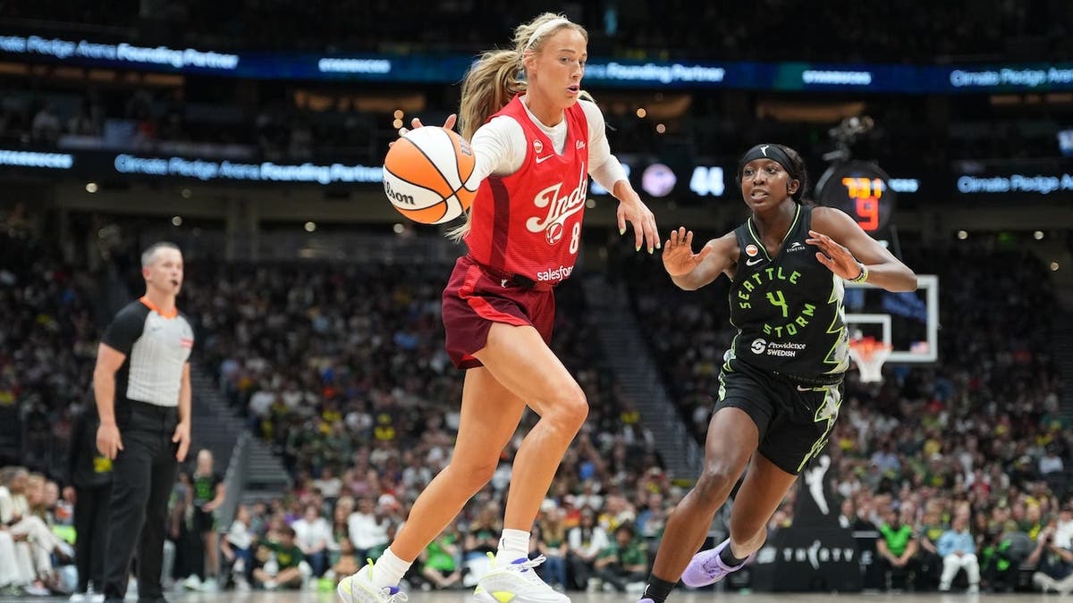 Sophie Cunningham of the Indiana Fever handles the ball against Flau'jae Johnson of the Seattle Storm.