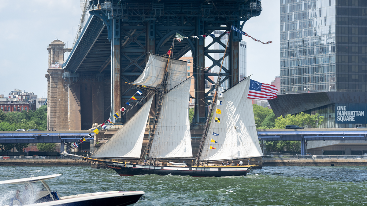 The tall ship Lynx sails under the Manhattan Bridge along the East River during a preliminary parade on July 3, 2026, in New York City.
