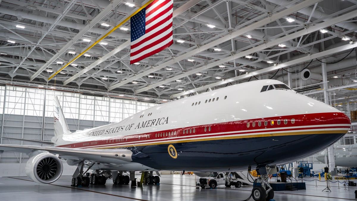 Photo of blue, white and red presidential plane inside a warehouse.