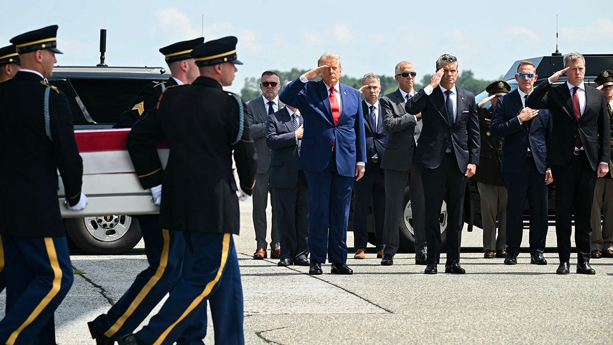 U.S. President Donald Trump salutes as a US Army carry team carries the flag-draped transfer case containing the remains of 1st Lt. Tyler James Feehan