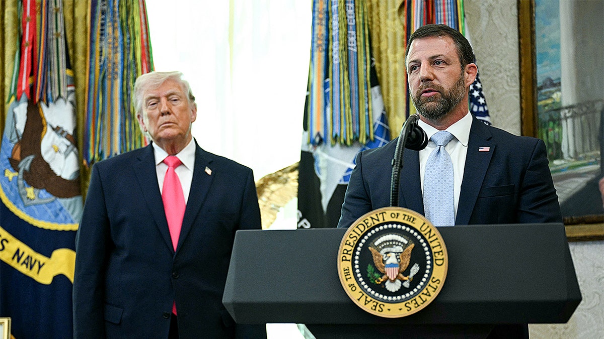 Donald Trump and Markwayne Mullin standing in the Oval Office as Mullin speaks.