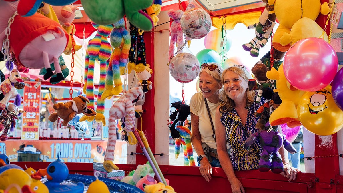 Two senior women visiting an outdoor traveling carnival