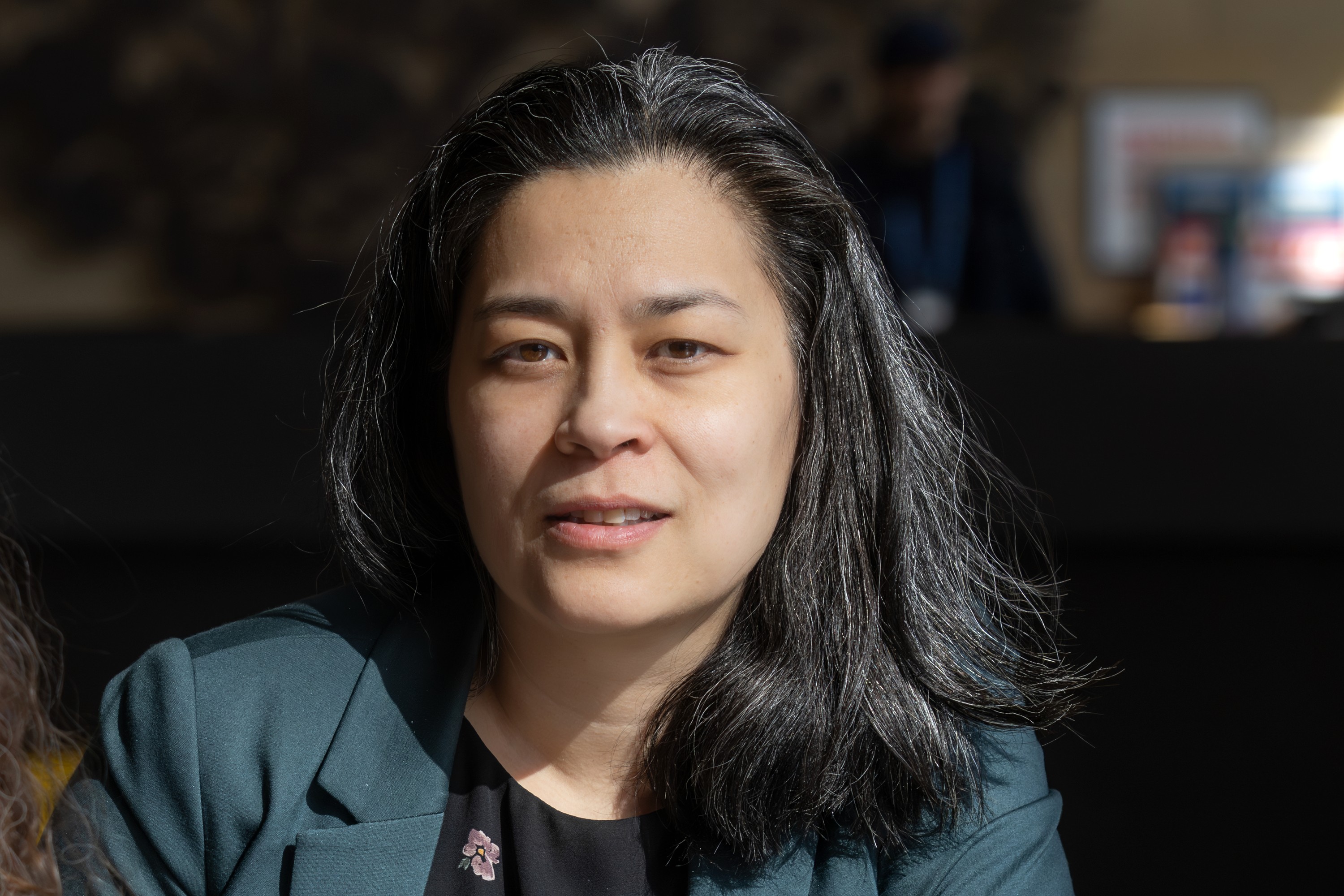 A woman looks at the camera with a neutral expression