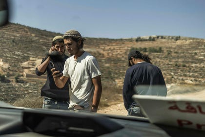 Settlers blocking Haaretz journalists from accessing the home of Palestinian residents in Qusra on Monday. Credit: Itai Ron Settlers blocking Haaretz journalists from accessing the home of Palestinian residents in Qusra on Monday.