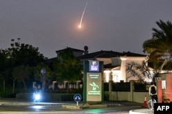 A cyclist watches as a projectile falls over Dubai on February 28.