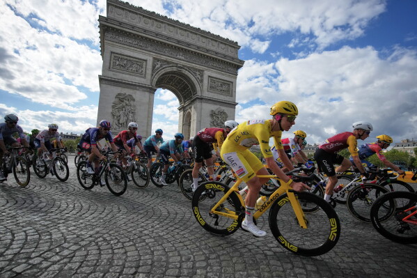 Slovenia's Tadej Pogacar, wearing the overall leader's yellow jersey, rides past the Arc de Triomphe during the last stage of the Tour de France cycling race with start and finish in Paris, Sunday, July 26, 2026. (AP Photo/Mosa'ab Elshamy)