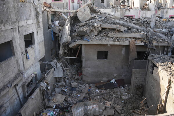 A Palestinian boy stands amid destroyed buildings at the scene of an Israeli airstrike in Nuseirat in the central Gaza Strip, Saturday, Aug. 1, 2026. (AP Photo/Abdel Kareem Hana) CORRECTION: Corrects to Saturday, not Monday.