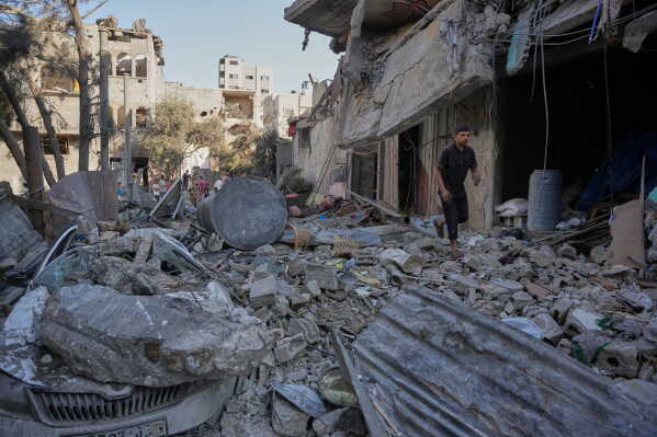 A Palestinian walks amid debris after an Israeli airstrike in Nuseirat in the central Gaza Strip, Saturday, Aug. 1, 2026. (AP Photo/Abdel Kareem Hana) CORRECTION: Corrects to Saturday, not Monday.