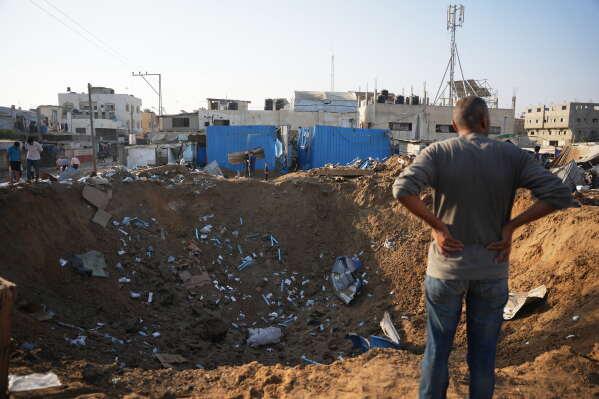 Palestinians inspect the scene of an Israeli airstrike near al-Aqsa Hospital in Deir al-Balah in the central Gaza Strip, Saturday, Aug. 1, 2026. (AP Photo/Abdel Kareem Hana)